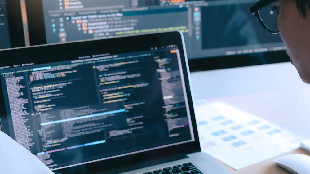 Person som ser på en datamaskin med kode på skjermen