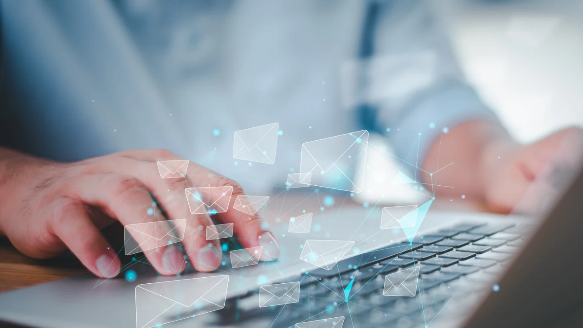 Hände tippen auf Laptop-Tastatur mit schwebenden E-Mail-Symbolen zur Darstellung digitaler Kommunikation.