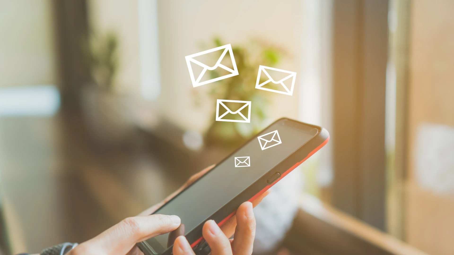Hand hält ein Smartphone mit animierten E-Mail-Symbolen, die aus dem Bildschirm aufsteigen.