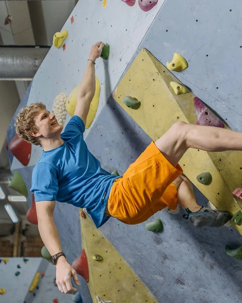 Climber holding on with one hand on wall