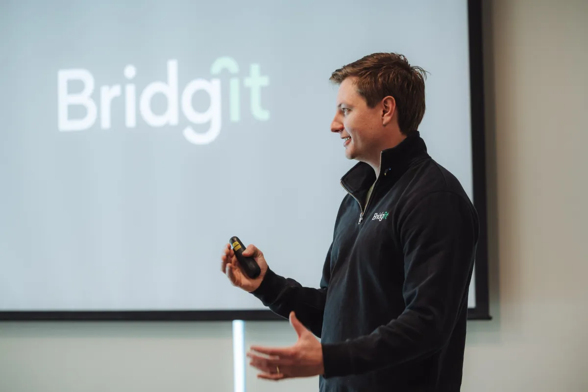 A Bridgit team member presenting in front of a Bridgit logo screen.