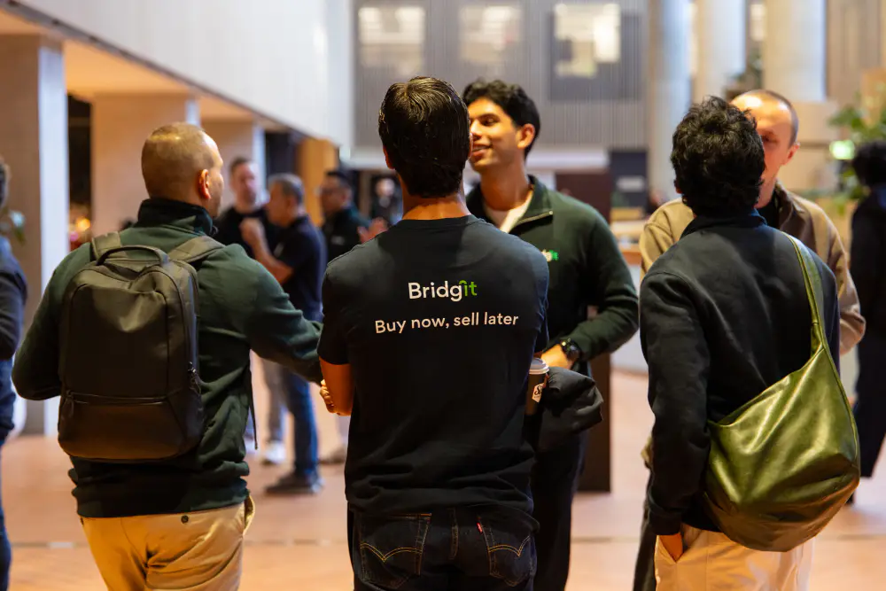 Bridgit team members in branded T-shirts chatting at a company event