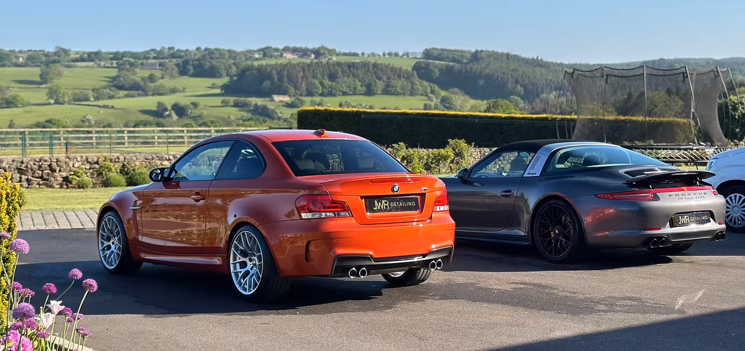 Cars parked across driveway overlooking fields