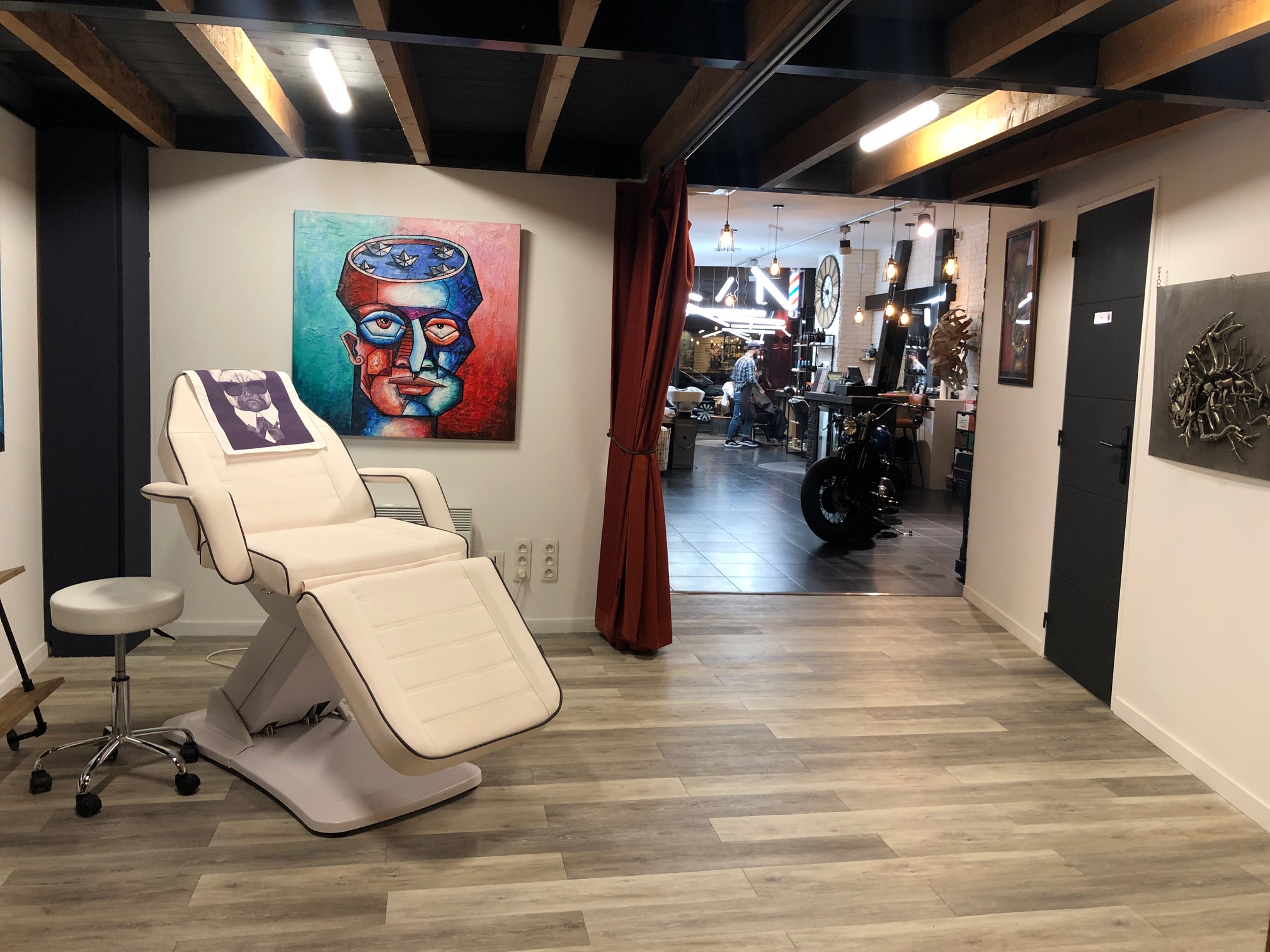 Espace soin avec fauteuil inclinable et tableau street art, INDUSTRIE Barbers Lyon