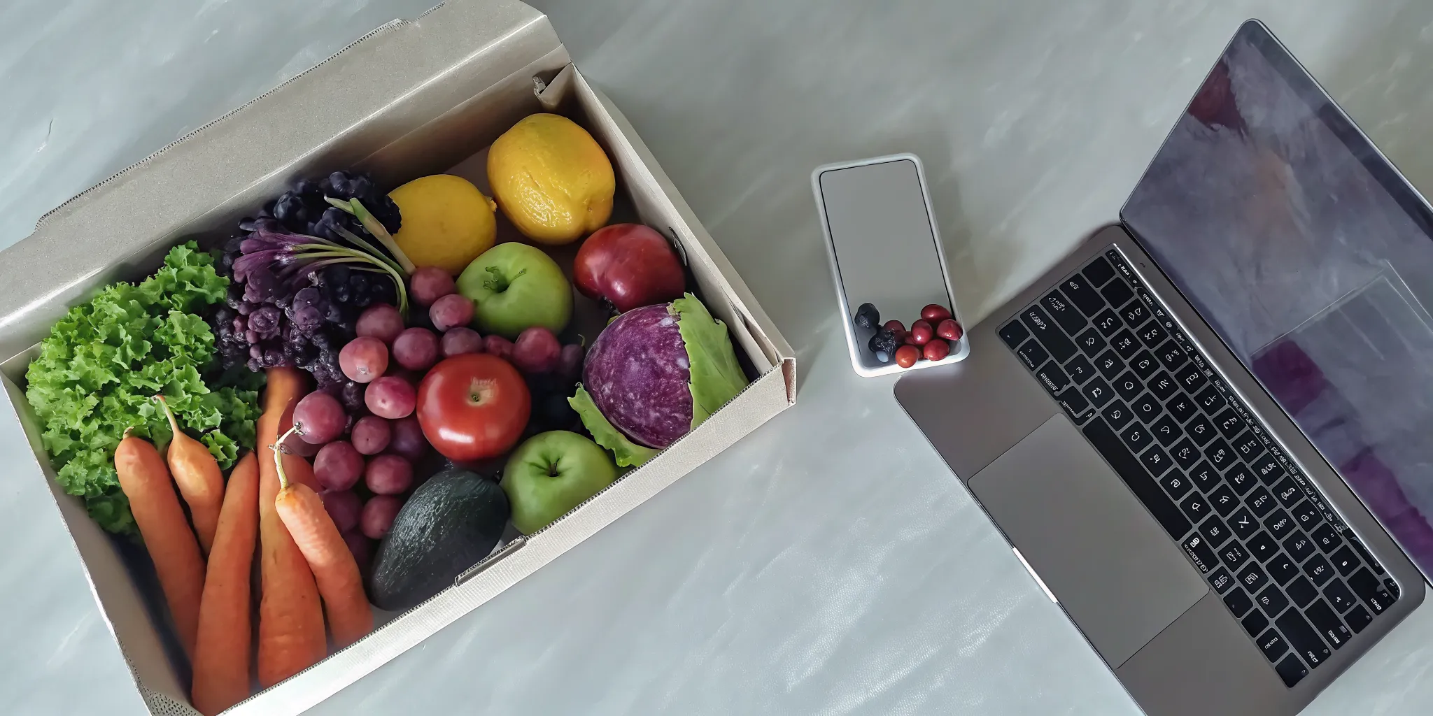 A box of fresh produce next to a laptop used to find the best delivery service.