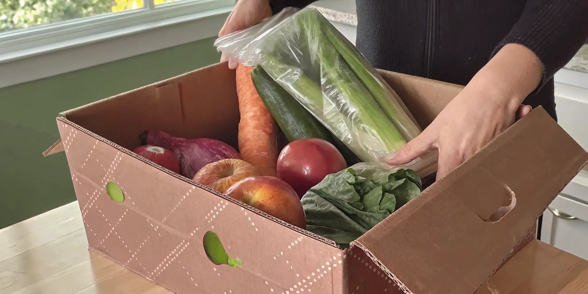 Fresh Ontario produce being unboxed from a grocery delivery box on a kitchen counter