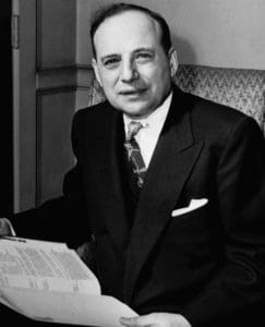 A man in suit and tie sitting at a table.