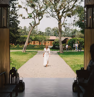 Woman in a white dress walking through the tropical gardens of Hacienda La Danesa.