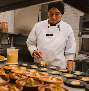 La chef Valeria prepara cuidadosamente platos gourmet en la cocina de Hacienda La Danesa.