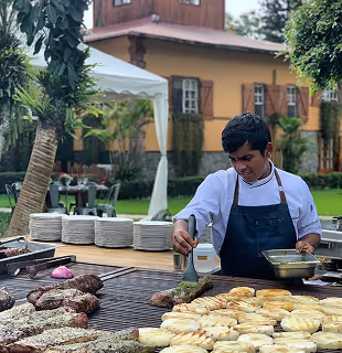 Chef preparando parrillas al aire libre para un evento en Hacienda La Danesa.