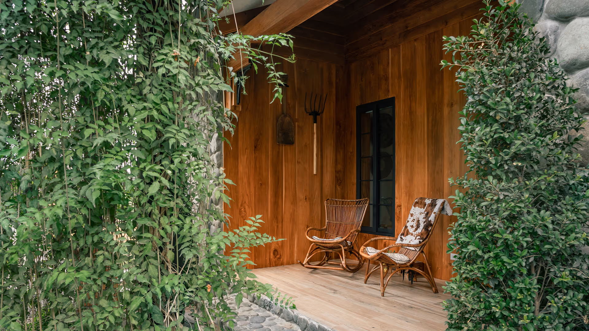 Rustic wooden terrace at Hacienda La Danesa featuring rocking chairs and country-style decor.
