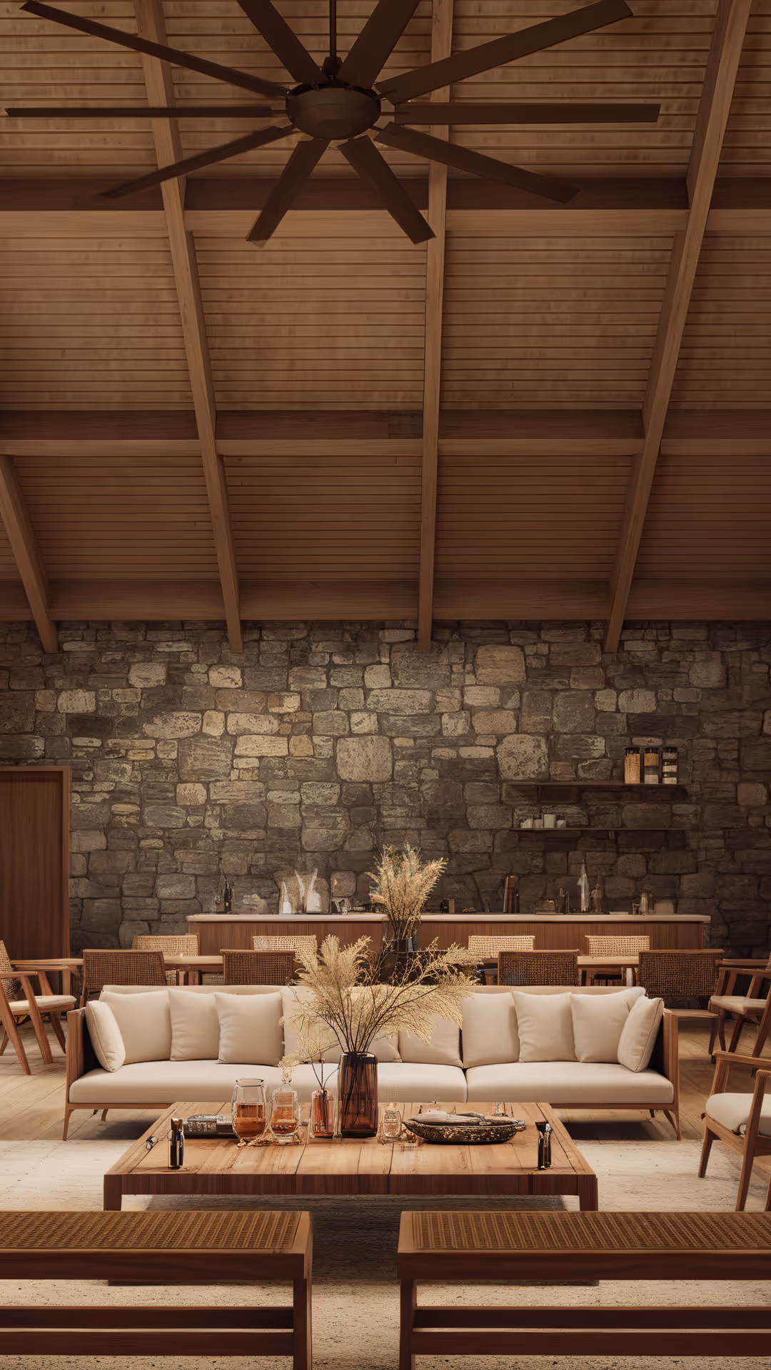 Luxurious lounge at Hacienda La Danesa featuring stone walls and wooden cathedral ceilings.