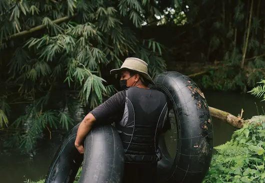 Guide carrying river tubes near the water at Hacienda La Danesa.