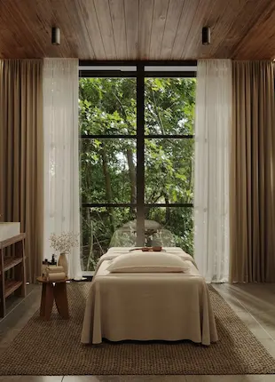Sala de masajes tranquila en el Wellness Center de Hacienda La Danesa con ventanal que da al bosque tropical