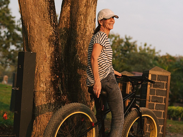 Smiling guest with a mountain bike at golden hour on the grounds of Hacienda La Danesa