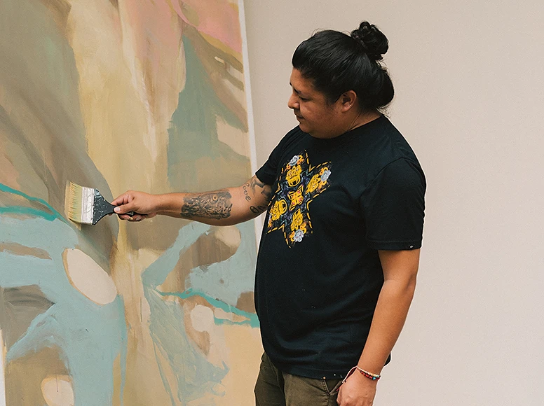 Ecuadorian artist painting the large abstract canvas displayed in the main lounge of Hacienda La Danesa