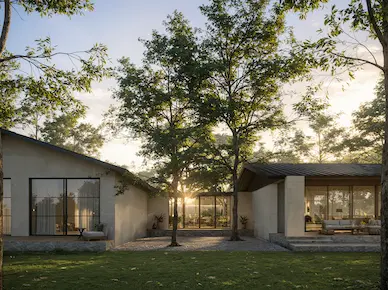 Dusk exterior of Hacienda La Danesa private residence showing two wings connected by a glass corridor amid mature tropical trees