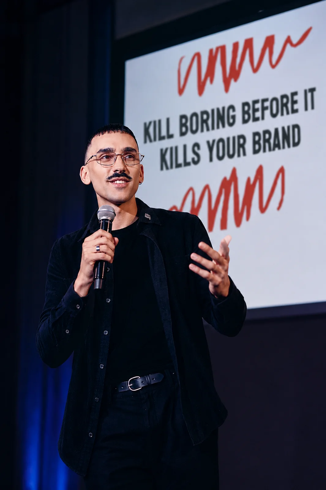 Marcus Willis on stage speaking about creative marketing for Kill Boring Dead