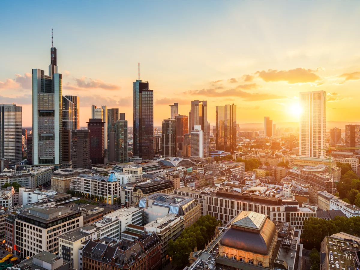 Frankfurter Skyline bei Sonnenuntergang mit Hochhäusern und goldenem Himmel.