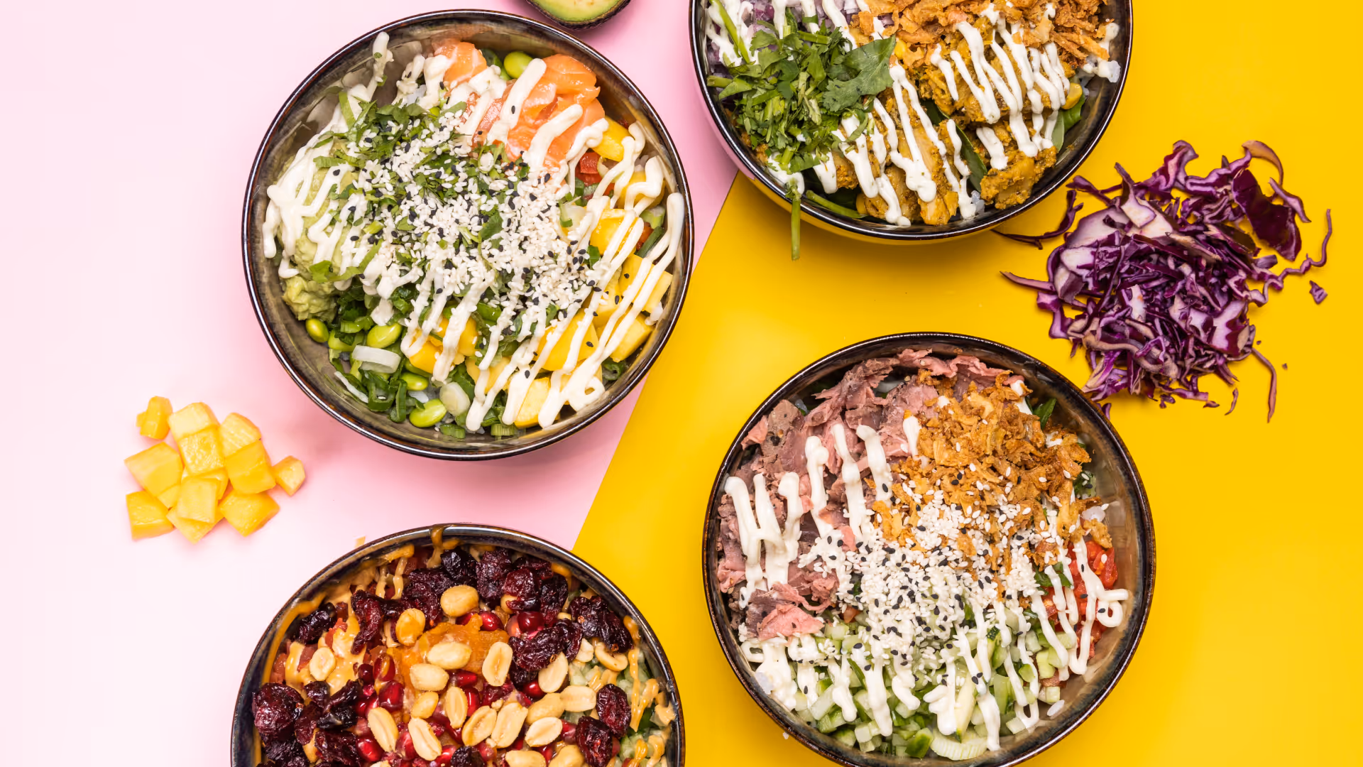 Vier bunte Poké-Bowls mit verschiedenen Zutaten wie Avocado, Lachs, Erdnüssen, rotem Kohl und cremigen Saucen auf rosa und gelbem Hintergrund.
