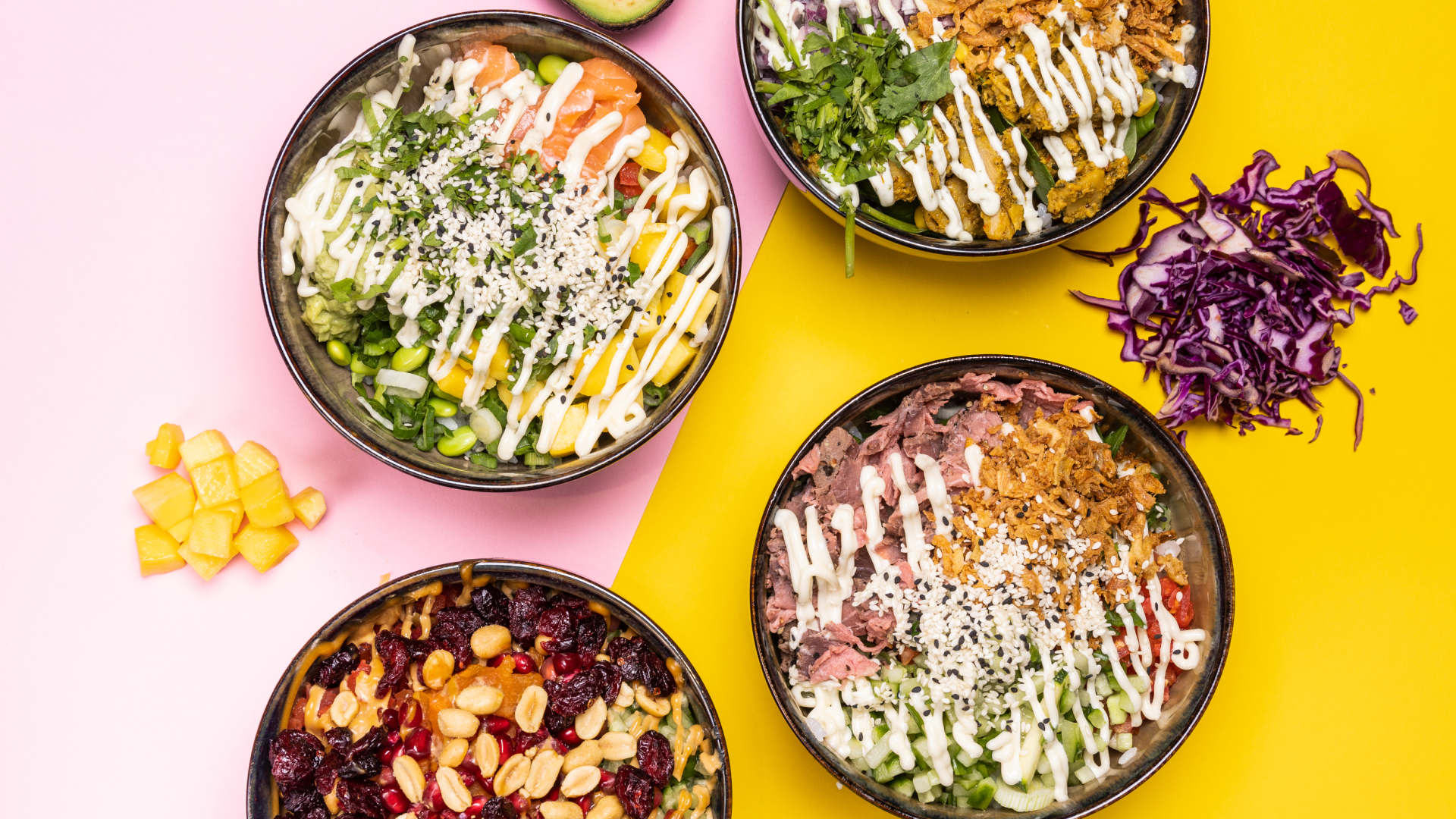 Vier bunte Poké-Bowls mit verschiedenen Zutaten wie Avocado, Lachs, Erdnüssen, rotem Kohl und cremigen Saucen auf rosa und gelbem Hintergrund.