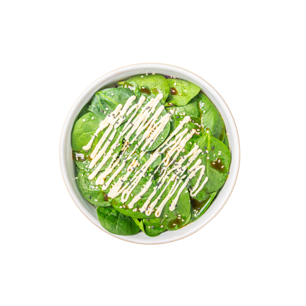 Schüssel mit frischem Spinatsalat, garniert mit Sesamsamen und einem Dressing aus Mayonnaise und Sojasauce.