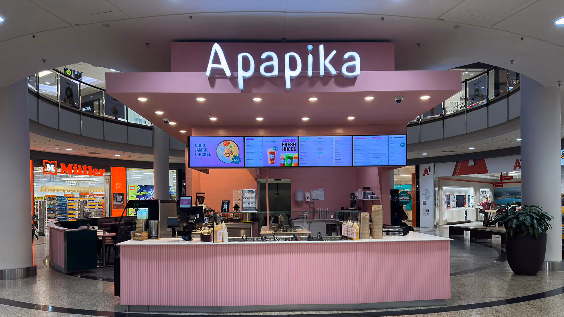 Apapika Foodstand in Einkaufszentrum mit rosa Theke und digitalem Menübildschirm