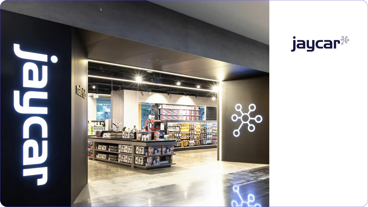 Modern Jaycar store entrance with illuminated branding and shelves stocked with electronic products and tools.
