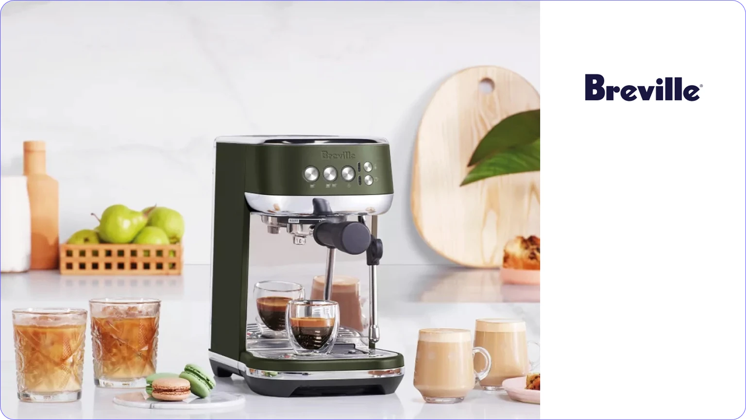 Breville espresso machine with two espresso shots, two iced coffee glasses, and two latte mugs on a kitchen counter.