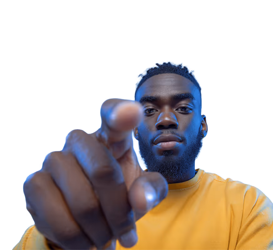 Close-up of a man with a beard wearing a yellow shirt pointing directly at the camera.