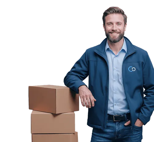 Smiling man in blue jacket leaning on a stack of three cardboard boxes.