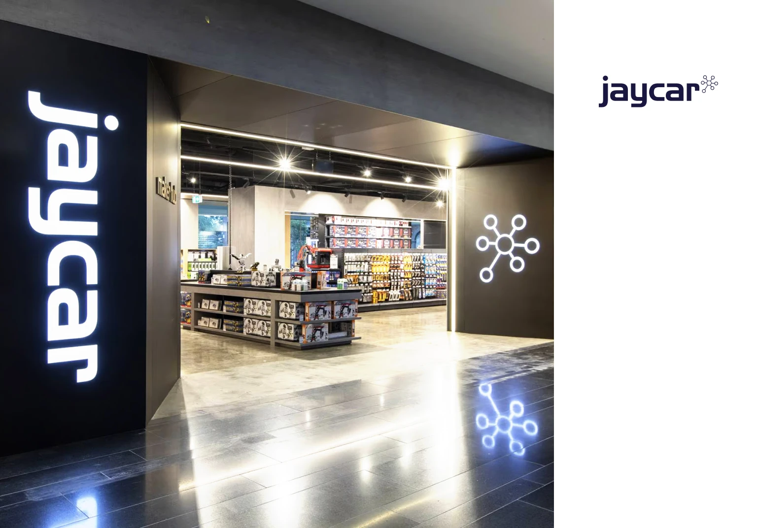 Entrance to a Jaycar electronics store with illuminated logo and product displays inside.