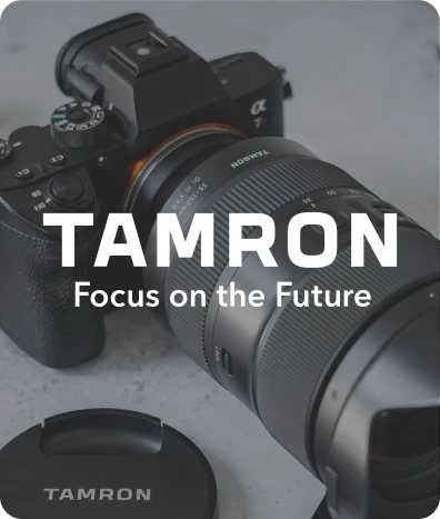 Sony camera with a Tamron telephoto lens and Tamron lens cap, with text saying 'TAMRON Focus on the Future.'