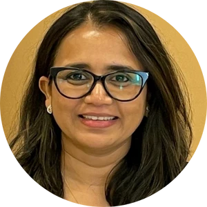 Woman with medium-length dark hair wearing glasses and small earrings, smiling against a yellow background.