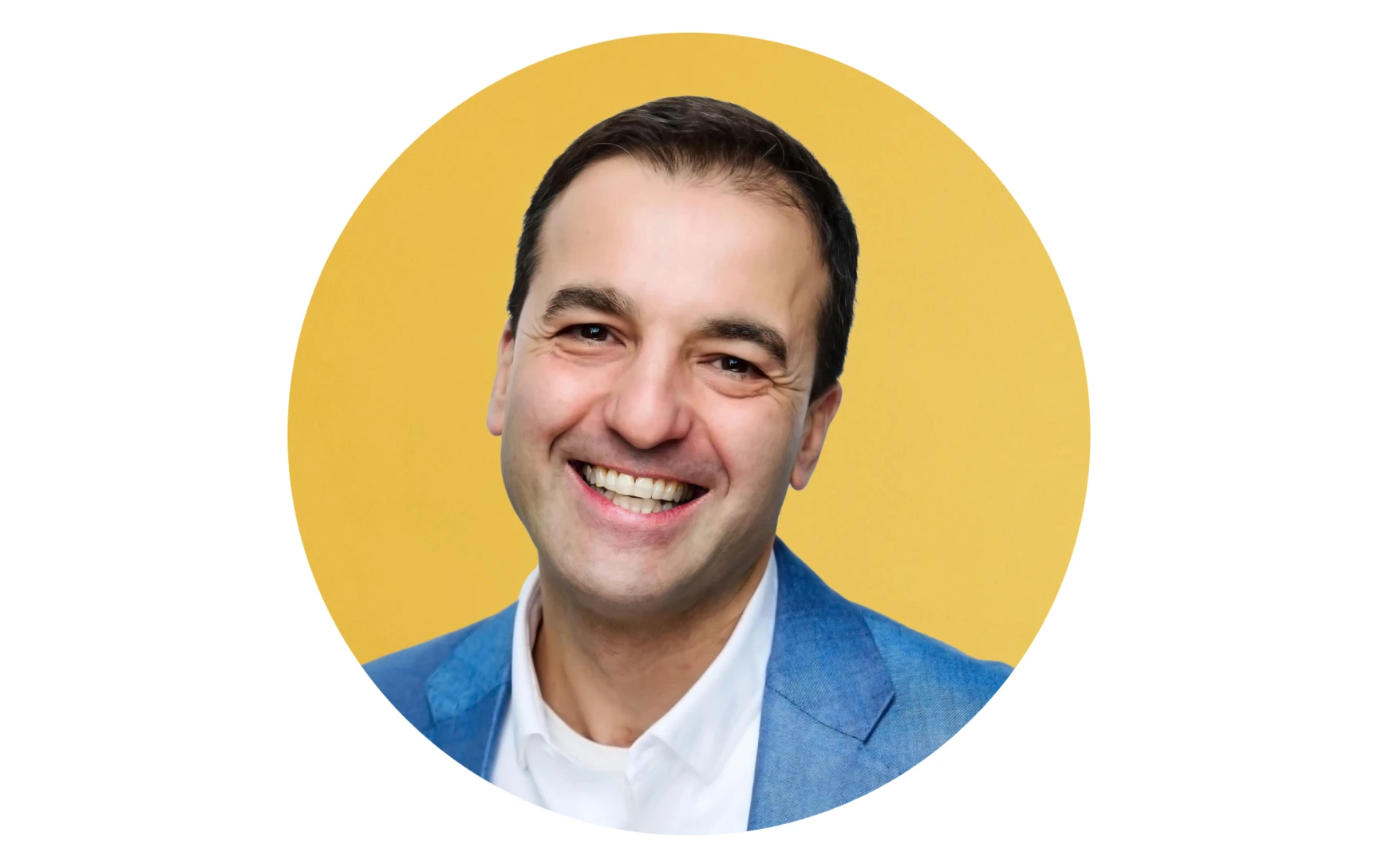 Smiling man wearing a blue blazer and white shirt against a yellow background.
