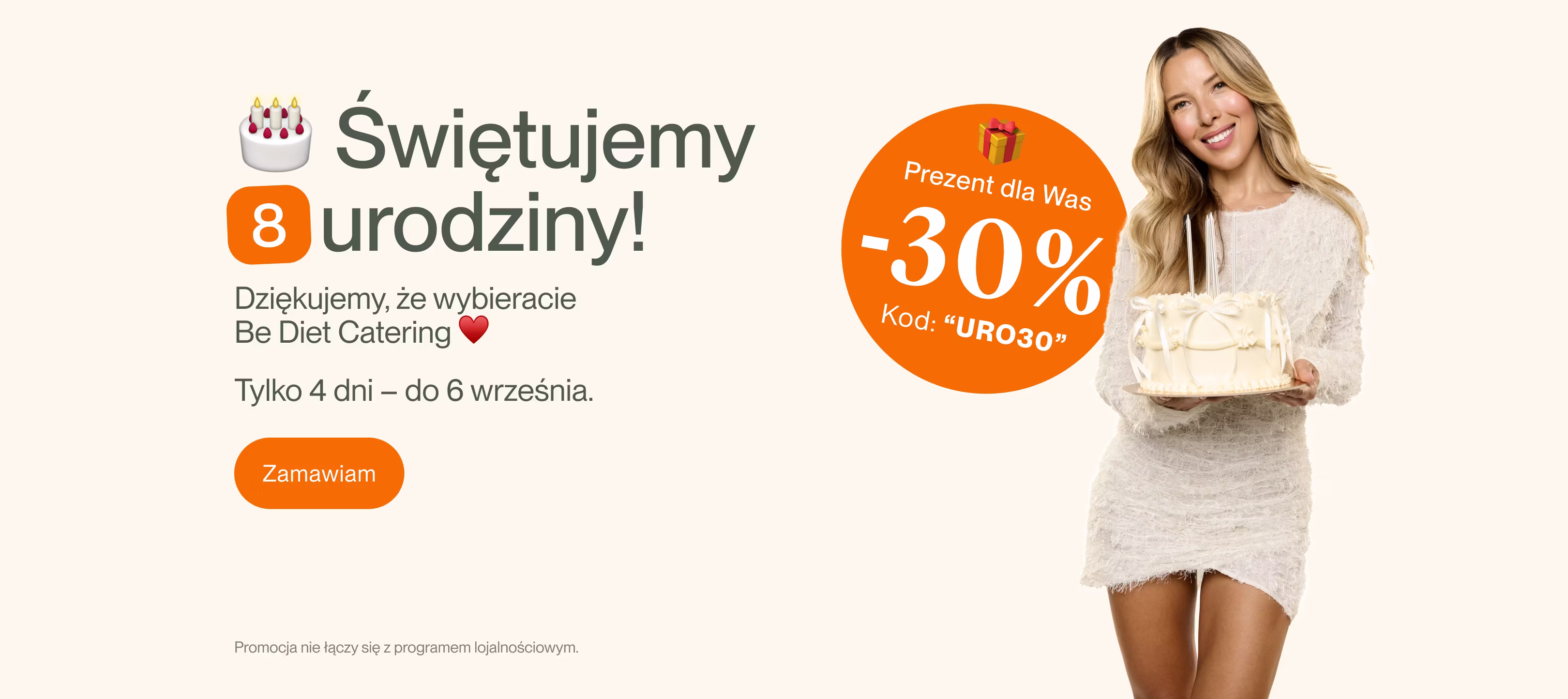 Trzy uśmiechnięte dorosłe osoby w kuchni, środkowa osoba w pomarańczowym fartuchu kucharskim, z przodu na blacie dwa soki i talerze z jedzeniem.