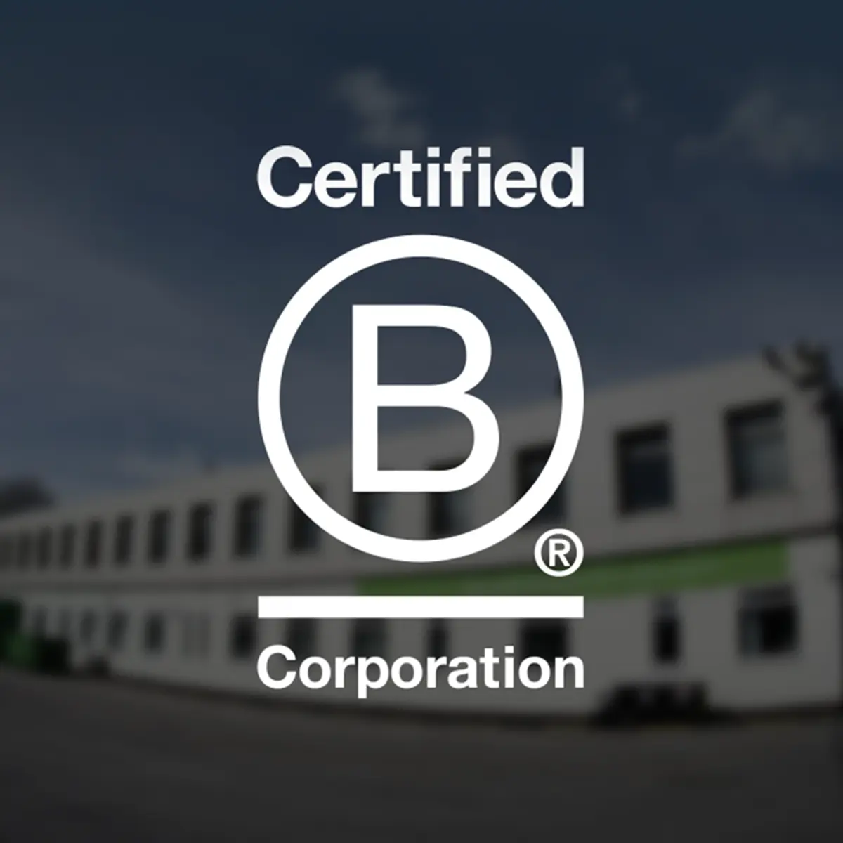 Certified B Corporation logo with a blurred building in the background.