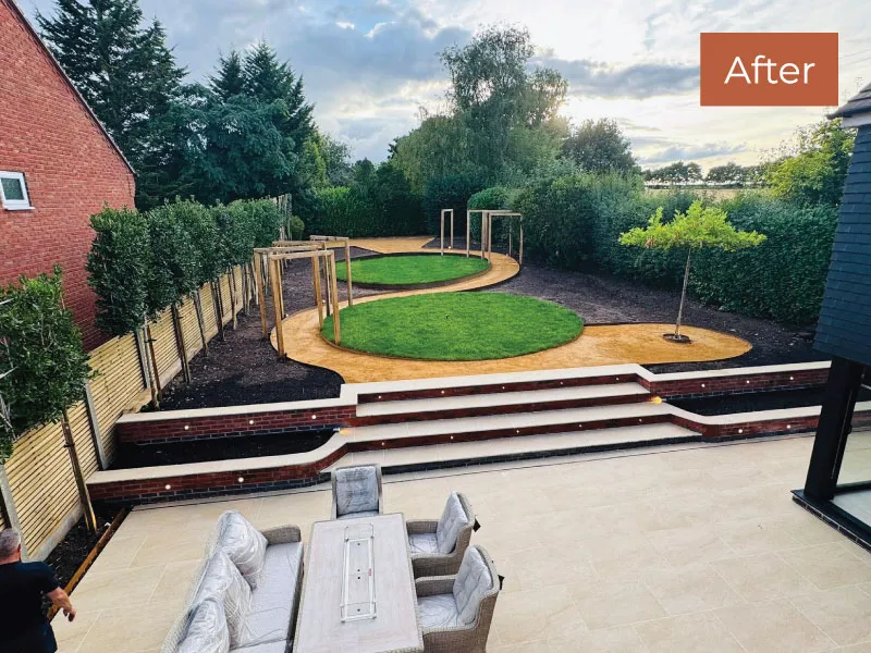 Patio with beige tiles, outdoor dining set, and curved wooden walkway around two circular grass areas in a landscaped garden.