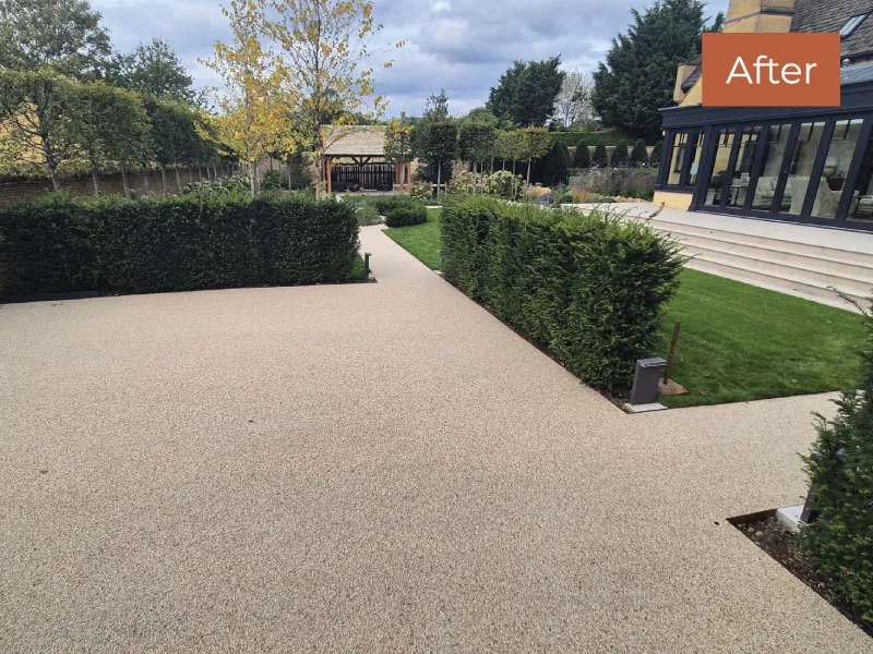 Clean, well-maintained garden path and lawn bordered by trimmed hedges beside a modern house.