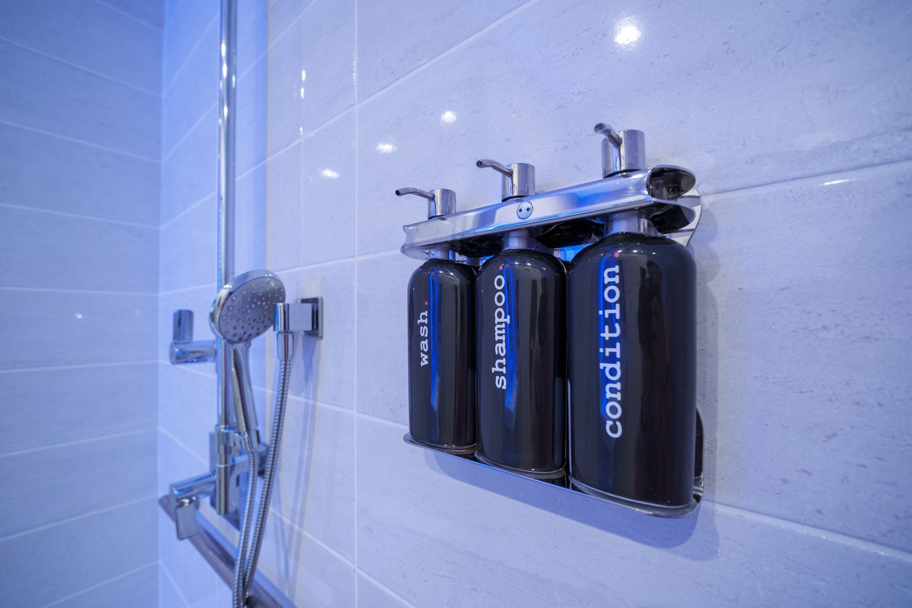 Private shower amenities inside a TRAIN Training House™ in McLean featuring clean, minimal design and high-quality bath products