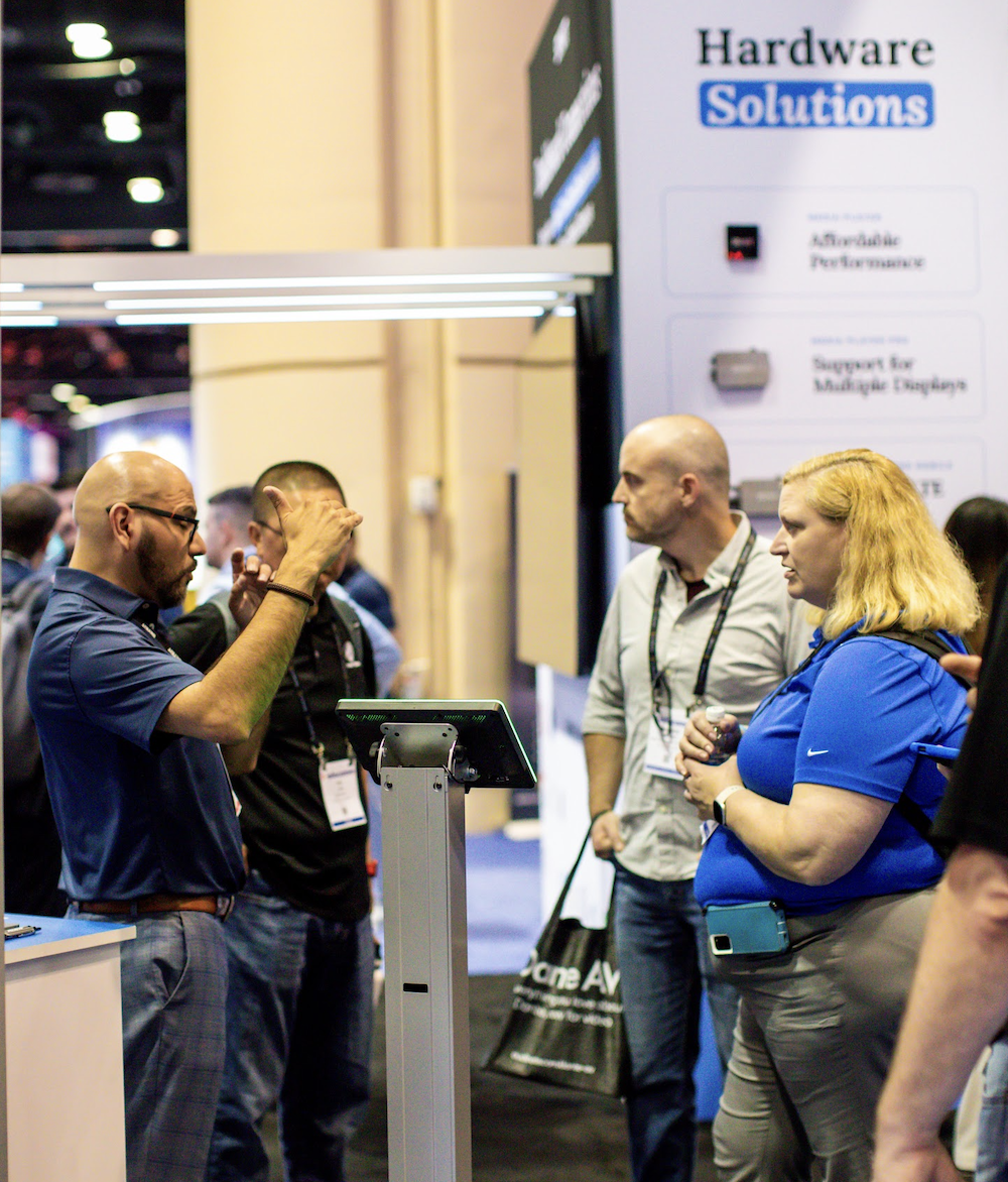 Trade show attendees interacting around a digital kiosk