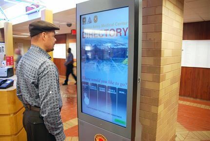 Man using an interactive digital directory kiosk
