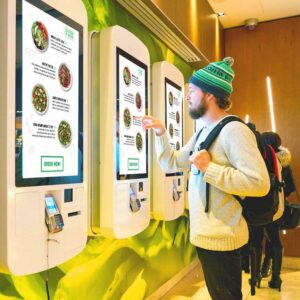 Man ordering food at a self-service touch-screen kiosk