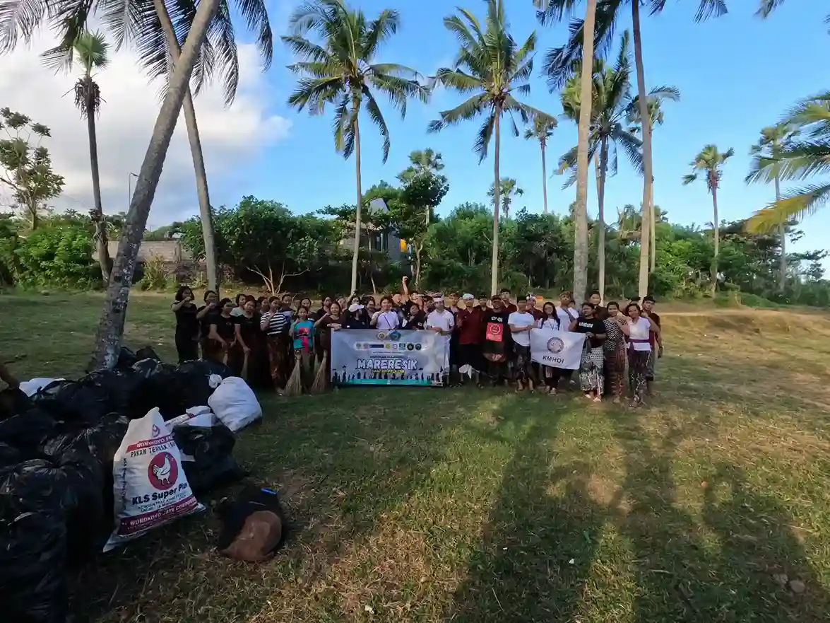 Community cleanup volunteers posing with collected waste bags in Seraya Village after Melasti beach cleanup