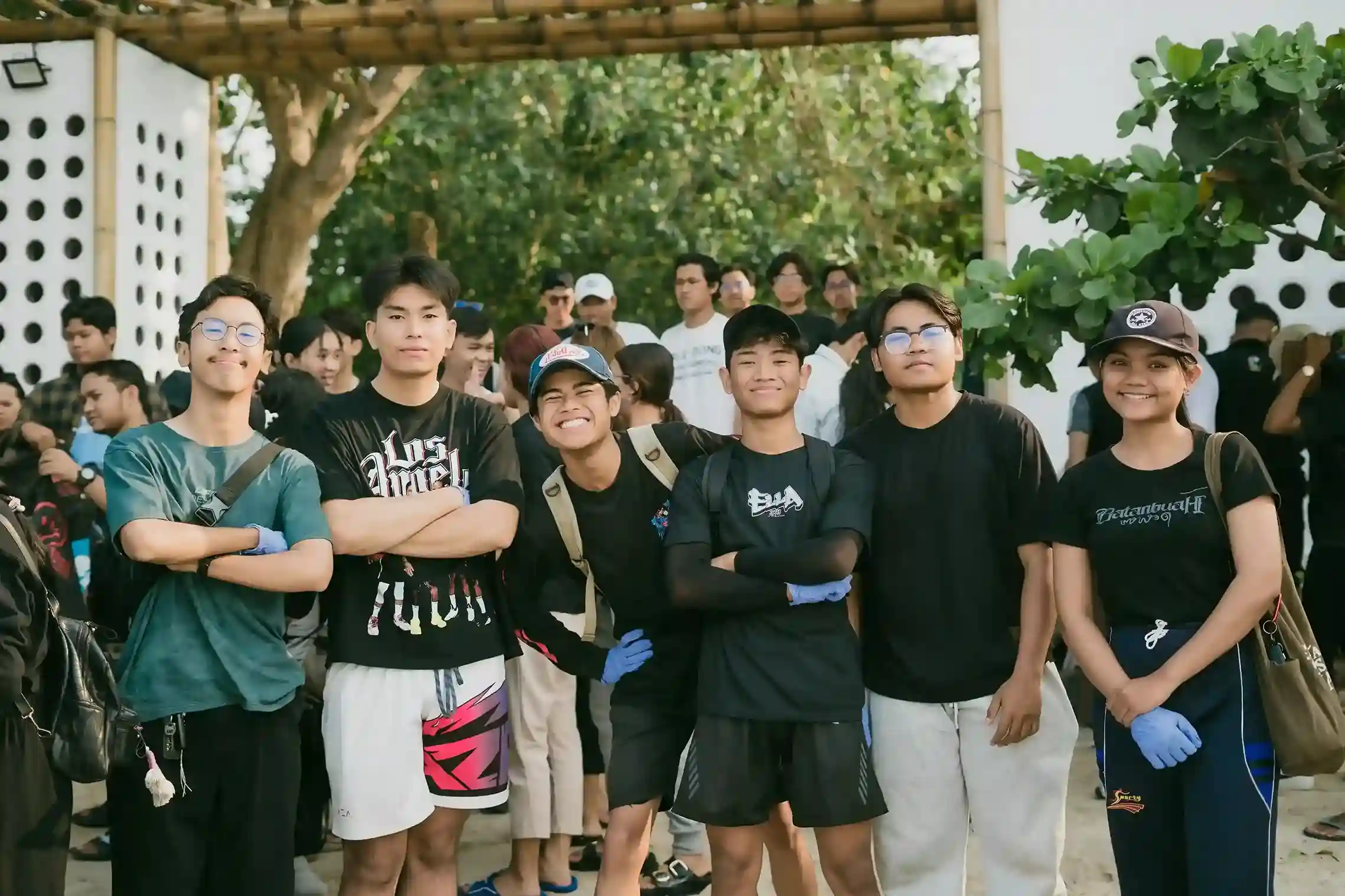 Volunteers smiling together at Kelan Beach cleanup event, wearing gloves ready for ocean conservation action