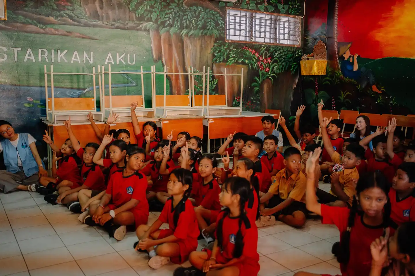 Students at SDN 5 Kuta raising their hands during an OceanHero education session
