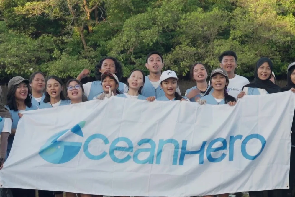 The Ecomora closing group with the OceanHero banner in the mangroves