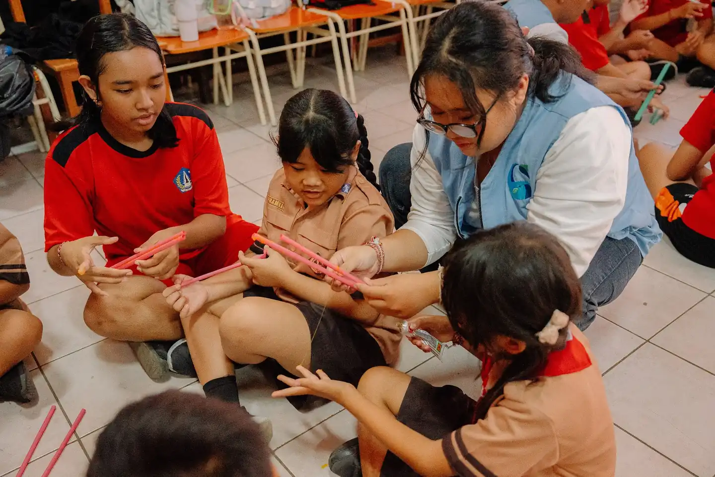Volunteers working with children on the classroom floor at SDN 5 Kuta