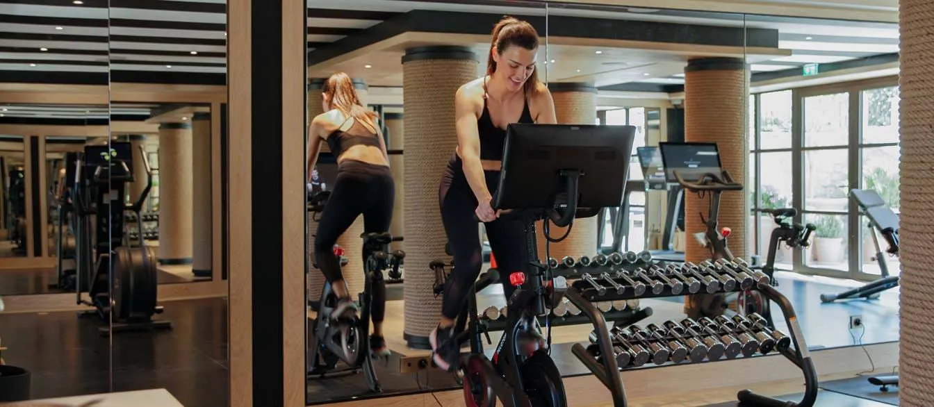Modernes Fitnessstudio mit Spinning-Bikes und Fitnessgeräten im AREV Hotel in Saint-Tropez.