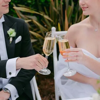 Noivos brindando com taças de champanhe durante uma recepção no hotel AREV em Saint-Tropez.